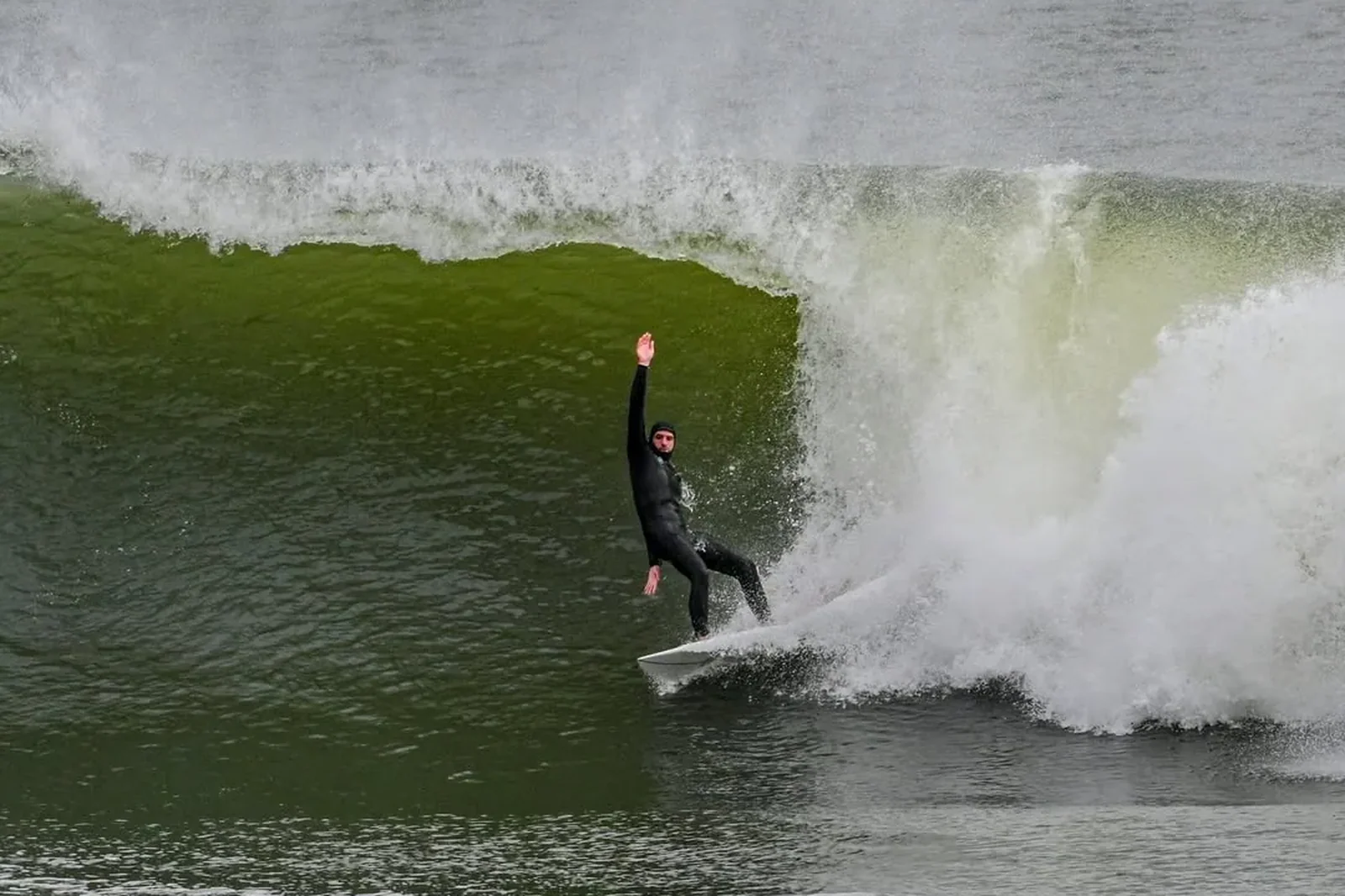 Surfista numa secção oca, fotografado da areia pela BAD SURF PHOTO